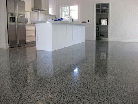 Polished concrete kitchen floor with white island and stainless steel appliances