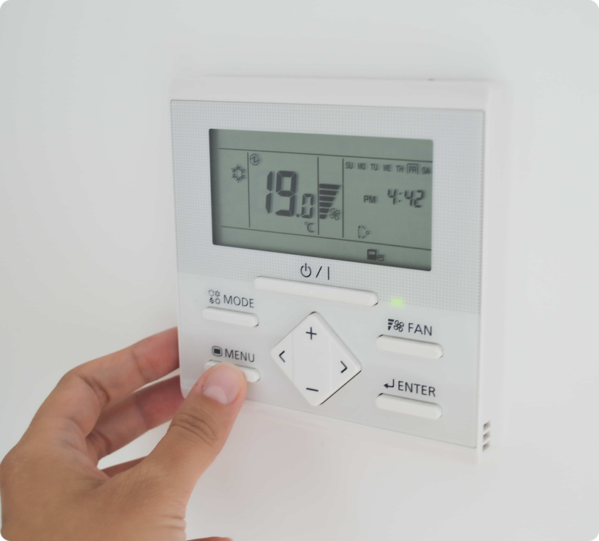 Électricien vérifiant le câblage d'un thermostat résidentiel avant l'installation.